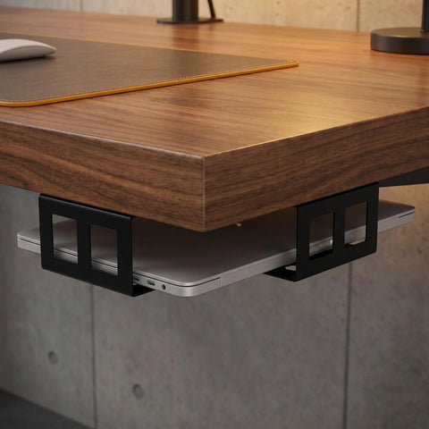 Sleek Under Desk Laptop Mount Rack Two Pack Black Steel Bracket With No Slip Eva Mats For Cramped Rooms And Hella Sturdy Daily Driver Workspace Bad Boy holding laptop under a wooden desk.