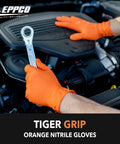 Mechanic using a wrench while wearing Orange 8 Mil Nitrile Disposable Gloves With Textured Grip For Automotive And Industrial Work