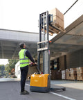 All Day Workhorse Full Electric Straddle Pallet Stacker And Warehouse Material Handler With 3300 Lbs Capacity And 98 Inch Lift Height lifting boxes in a warehouse.
