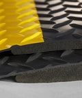 Close-up of Heavy Duty Anti Fatigue Floor Mat 2 By 7 Feet Extra Thick Fifteen Sixteenths Inch Diamond Plate Standing Pad, showing yellow border.