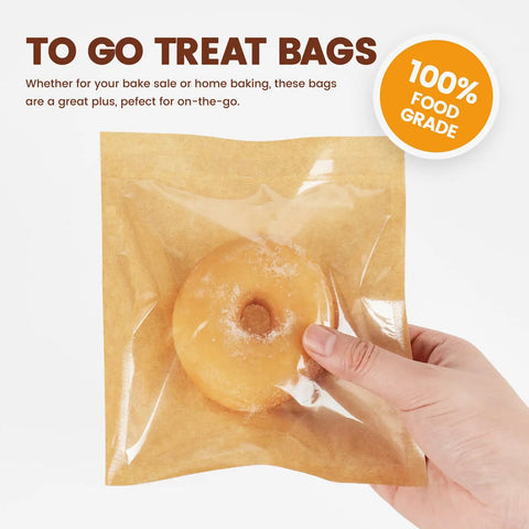 100 Pack Heat Sealable Cookie Bags With Window Grease Resistant Grab And Go Bakery Bags, hand holding bag with donut inside