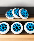 Set of 6 blue-core 90mm 85A inline skate wheels for outdoor replacement on shelf, designed for smooth city cruising.