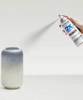 Pro Grade Painter Touch Spray Primer In Flat Gray Six Pack Of Twelve Oz Cans For Wood Metal And Plastic With Fast Dry Formula And Zero Hassle Any Angle Grip Application, spray can in hand above a textured vase.