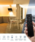 Hand holding remote in modern living room with 52.5ft 24V Dimmable Led Strip Lights Tunable White 3000K to 6000K