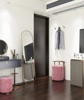 Vanity room with cream white peel and stick contact paper on walls, featuring a mirror, pink stool, and cabinets.
