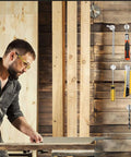 Man working in woodshop, Six Pack Super Strong Neodymium Disc Magnets With Double Sided Adhesive holding tools on wall.