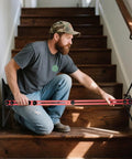 Man using Stair Gauge And Layout Tool Set With Flexible Extension Beams For Precise Measuring And Scribing Of Stair Treads