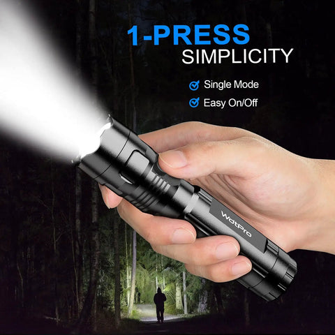 Hand holding a black LED flashlight shining bright in a forest, highlighting the text '1-Press Simplicity' for Four Pack LED Flashlights With Included Batteries For Emergency Prep And Camping The Bright EDC Lights Deliver High Lumens In A Simple Single Mode Design Perfect For Home Car Outdoor Adventures And Hurricane Prep.