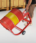 Beefy Steel Drum Cradle With Dependable Rolling Wheels And Fold Back Dump Bar For Serious Fifty Five Gallon Vessel Hauling and Zero Sweat Liquid Transferring On Any Commercial Site, red cradle with drum being wheeled.