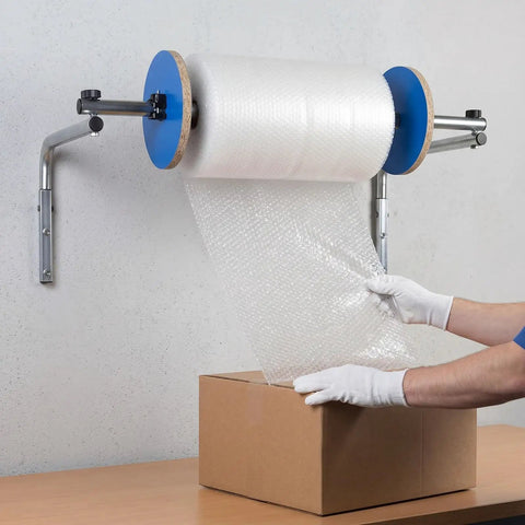 Slick Wall Mount Bubble Wrap Dispenser With Heavy Duty Galvanized Steel And Smooth Tidy Rewind Ready Packs Shipping Fits Air Cushion Film Rolls Up To Forty Inches Wide, dispensing bubble wrap onto a box.