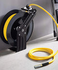 50ft Hybrid Air Hose With Half Inch MNPT Ends And Bend Restrictors, coiled on reel, yellow hose, 300 PSI, mounted on wall