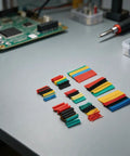 Cool 164 Pc Heat Shrink Tubing Kit With 2 To 1 Ratio Polyolefin Wire Cable Sleeve For Electricians Featuring Eight Sizes From One Mm To Fourteen Mm And High Tensile Strength For Serious DIY Wrangling And Long Lasting Insulation On All Your Wiring. Assorted heat shrink tubing sizes on an electronics bench
