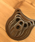 Know Your Limits KYL Gong Targets 6 Pack from One Inch to Six Inch Gongs Three Eighths Inch Thick stacked on wood surface.