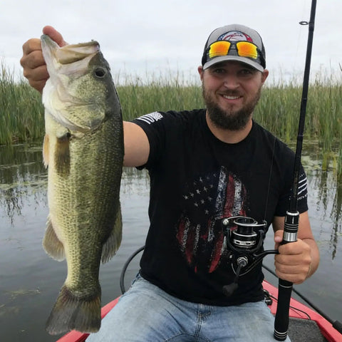 Angler holding a large fish with a Telescopic Fishing Rod And Reel Combo With Carrier Bag For Freshwater Angling Lightweight Two Piece Set