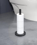 Free Standing Toilet Paper Holder Stand In Matte Black, Built From 304 Stainless Steel, holding 3 rolls in bathroom.