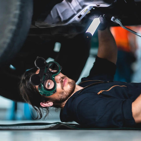 Man using Kickass Dual Flip Up Welding Goggles Built Tough As Nails With Impact Resistance under a vehicle.