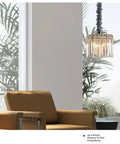 Modern Crystal Chandelier With K9 Crystals And Warm Gold Frame illuminating a contemporary living room with brown armchair