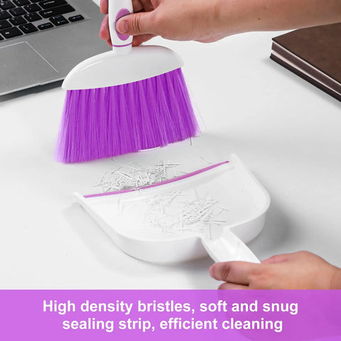 Mini Dust Pan And Brush Set With Teeth For Tight Spaces Flat Broom For Keyboards Desks Sofas Drawers And Cars, Portable Home Clean Up Kit For Home Office Or Outdoor Use, Purple being used to clean paper scraps on a desk.