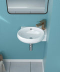 Small round white ceramic bathroom sink with modern faucet on turquoise wall background
