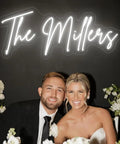 Bride and groom under Personalized Neon LED Sign For Weddings And Events, Battery Or Plug Operated Lit Up Name Logo