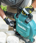 Game Changing Cordless Leaf Blower Kit Equipped With A Brushless Motor Pumping 473 CFM And 120 MPH Air With Zero Hassle Cruise Control and Rapid Swap Batteries for Knocking Down Piles and Hauling Leaves Straight, user adjusting battery.