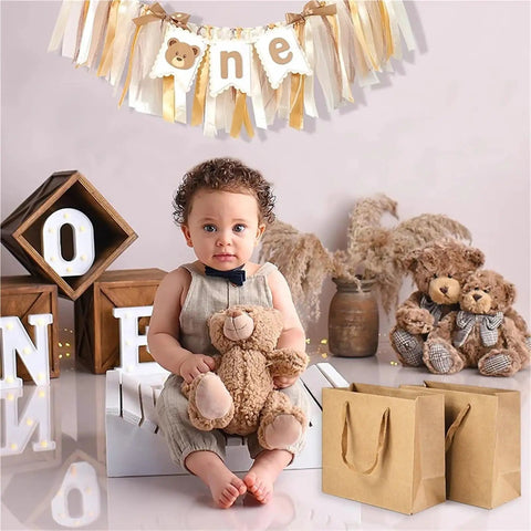 Kraft Paper Gift Bags Set Of 20 For Birthday Bashes And Weddings, beside a child with teddy bears and "one" banner decor