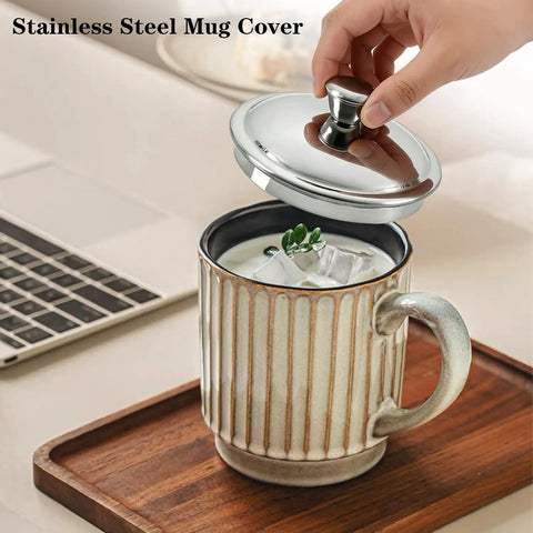 Solid Stainless Steel Universal Mug Lid Keeps Your Morning Grind Hot And Clean With Zero Fuss on a ceramic mug with ice.