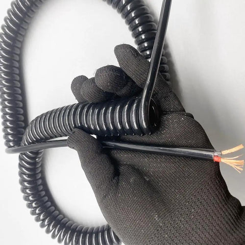 Hella Flexible Spiral Power Cord Featuring Rock Solid Bare Copper Conductors With Heavy Duty Telescopic Design for industrial sensor wiring, held in gloved hand.