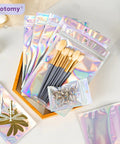Holographic Packaging Bags 3.1x4.7 Inch Resealable Foil Mylar Pouches with makeup brushes and key rings, durable and clear shine.