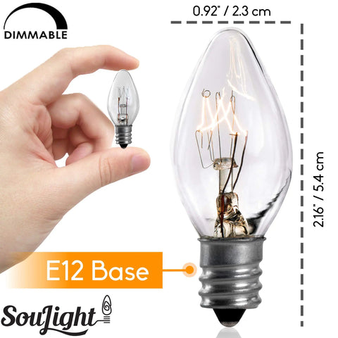 Hand holding a 7 Watt Night Light Replacement Bulb with E12 Candelabra Base, clear glass incandescent for C7 lamps.