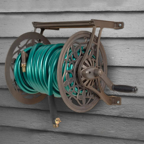 NeverLeak Decorative Wall Mount Hose Reel In Brown For Outdoor Yards Holds 125 Ft Of Five Eighths Inch Hose With Durable Corrosion Resistant Metal Construction And Included Leader Hose For A Leak Free Easy Hose Storage Station mounted on wall.