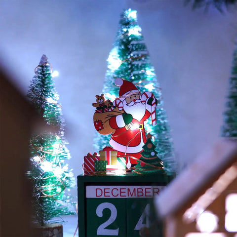 Santa with gifts surrounded by illuminated cool white trees, showcasing the Two Pack 33 Ft 100 LED Battery Operated Fairy String Lights.