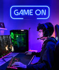 Teen playing video games under Lit Gaming Neon Sign Blue LED Wall Decor For Game Room Setup Dope Neon Light For Teen Boy Room, Gamer Wall Art