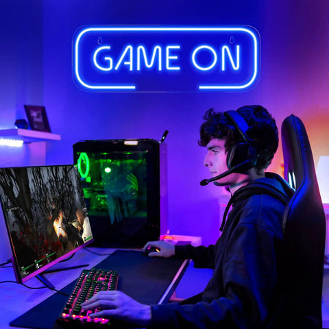 Teen playing video games under Lit Gaming Neon Sign Blue LED Wall Decor For Game Room Setup Dope Neon Light For Teen Boy Room, Gamer Wall Art