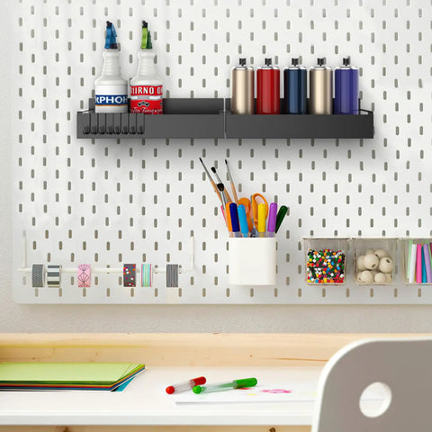 Four Pack Magnetic Spray Can Holders For Garage And Home Workshop Grab And Go Wall Mounted Tool Organizer With Open Access Design To Hold Paint Cans Oils Cleaners And Aerosol Cans on white pegboard wall, holding various spray cans and bottles, surrounded by organized art supplies.