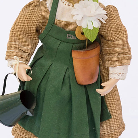 Doll in brown dress with green apron holding a flower pot and watering can, accessories for 100Pc Mini Buttons For Doll Clothes DIY Fasteners Kit