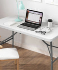 Heavy Duty 4 Foot Folding Table For Indoor Outdoor Use With Handle Portable Square Dining Card Table Waterproof Durable Plastic Top 330 Lb Weight Capacity Ideal For Picnics Parties Camping And More with laptop, lamp, books, and cup on top in home office setting