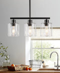 Sleek Black Three Light Kitchen Island Pendant Lamps Using Dimmable E26 Base illuminating a modern kitchen with clear glass shades.