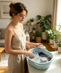 Woman using Portable USB Mini Washing Machine With Dead Simple Deep Clean Stain Removal Compact Travel Clothes Washer in a bright room.