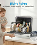 Woman using Self Contained Countertop Dishwasher With Built In Water Tank And Gentle Baby Care Mode, showcasing sliding rollers and dishes.