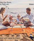 Family on Sandproof And Waterproof Beach Blanket 7x7 Ft Extra Large Mat With Stakes enjoying picnic by the sea on sand