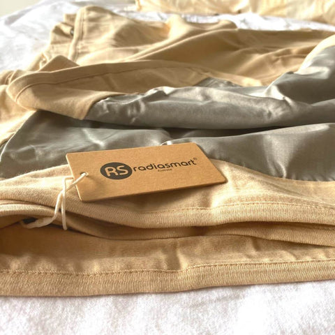 EMF Shielding Large Bed Blanket Made From Organic Cotton With Silver Lining For Daily Sleep Protection folded on a bed