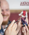 Person painting miniatures with brush, using Green Stuff 2 Part Modeling Clay For Miniatures Moldable Putty Modeling Compound 20cm Epoxy.