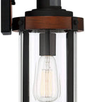 Rock Solid Black Motion Sensor Outdoor Wall Sconce With Zero Fuss Industrial Craftsmanship And Reliable Nighttime Security Lighting For Front Porch Or Driveway, close-up view of fixture with clear glass and black accents.
