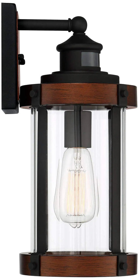 Rock Solid Black Motion Sensor Outdoor Wall Sconce With Zero Fuss Industrial Craftsmanship And Reliable Nighttime Security Lighting For Front Porch Or Driveway, close-up view of fixture with clear glass and black accents.