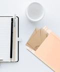 Heavy Duty Bubble Mailers 13x18 And 4 Inch Foam Padding, envelopes on desk with notebook and cup