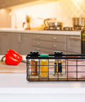 Farmhouse Small Metal Wire Storage Basket With Wooden Bottom Black Rustic Organizer holding spices on kitchen counter