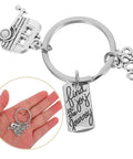Silver Zinc Alloy Camping Keychain Ultra Lightweight Travel Themed Key Ring with charm and engraved tag on a hand