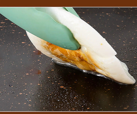 Egg being lifted with tongs on Thin 9.4 Inch Iron Grill Pan With Nonstick Coating For Stovetop Cooking, indoor use.