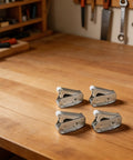 Set Of Four Spring Loaded Latches For Closets Cupboards And Cabinets In Stainless Steel With Easy Push To Open Design on wooden table